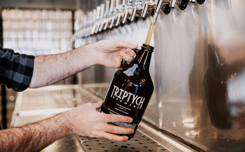 Growler getting refilled with beer at Triptych Brewing