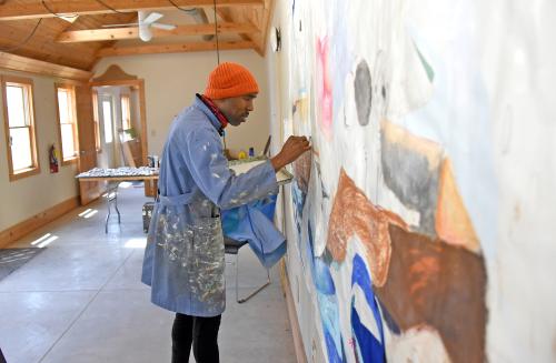 Artist painting a mural in Champaign-Urbana