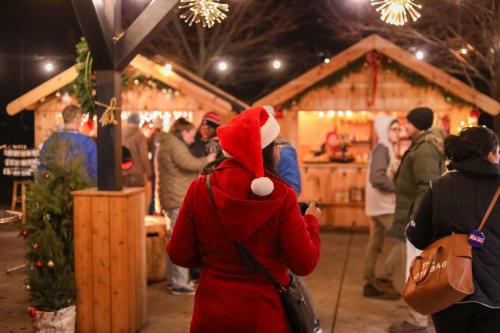 woman in a santa hat attending the Riggs Christmas Market